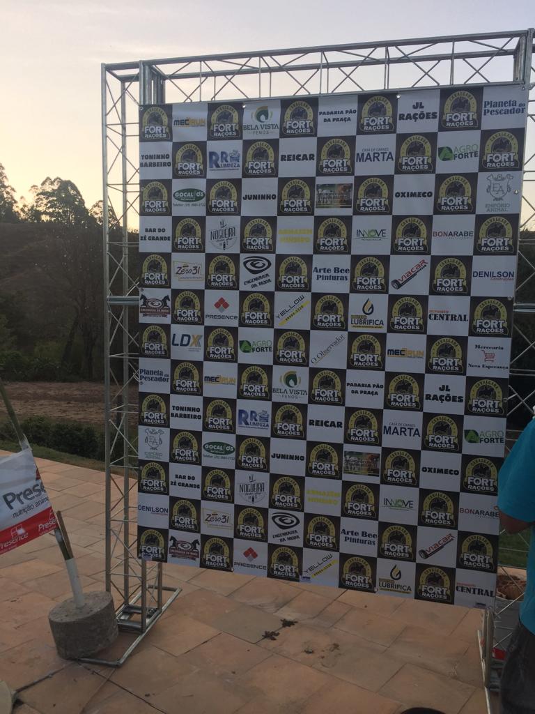 Backdrop em lona com logos de patrocinadores montado em estrutura de treliça
