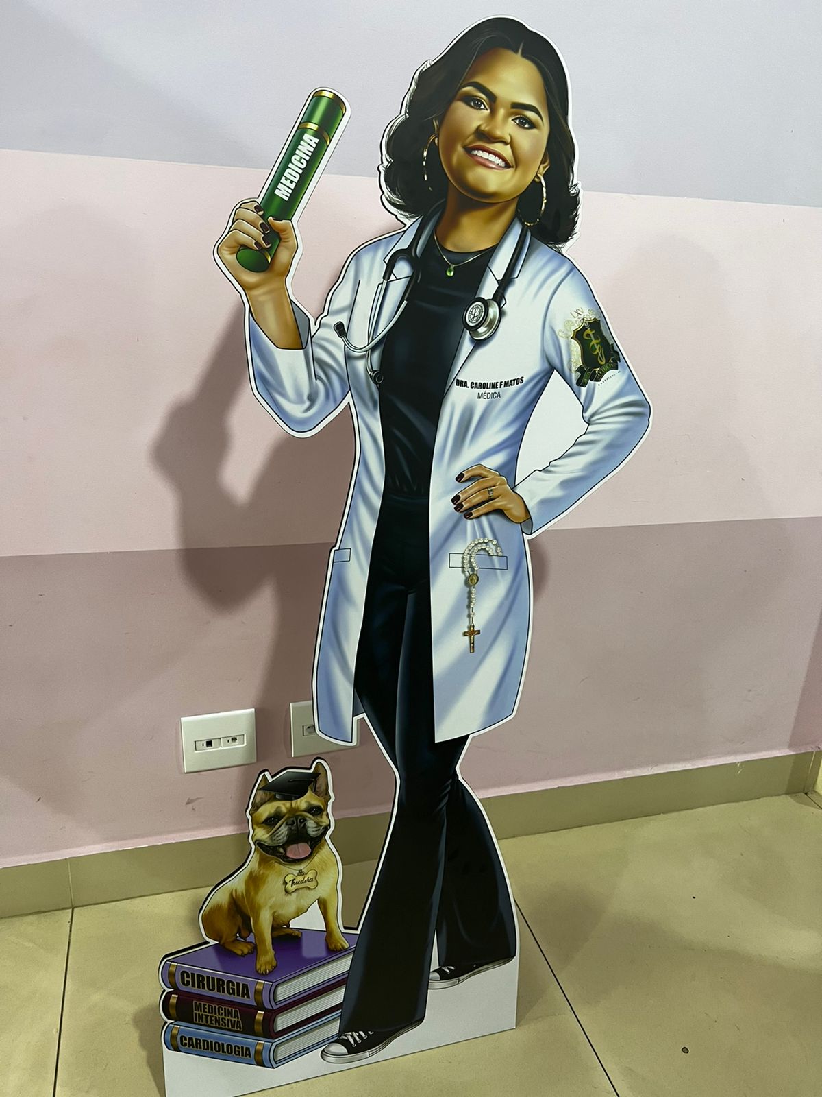 Totem em tamanho real de formanda em medicina com recorte de pet e livros